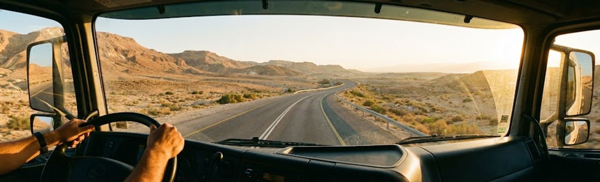 ידיים אחזות הגה של משאית על רקע כביש